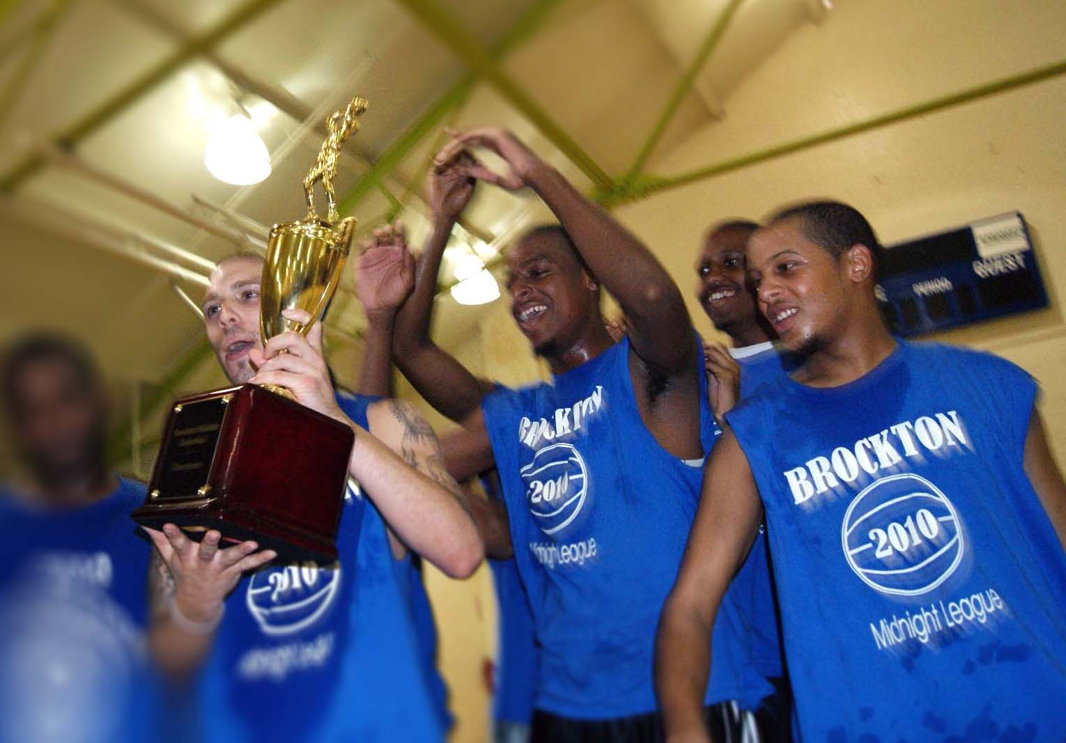A group of youths celebrating together their win with trophy.